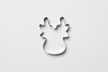 cookie cutter in form of deer on white colored paper background. isolated. close up. mock up