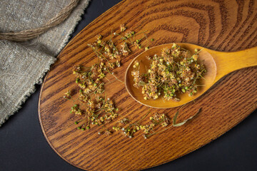 Dried linden on a wooden spoon. Linden on a wooden surface. Healing herbs.