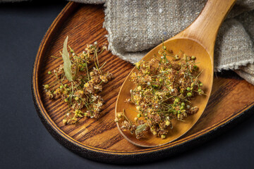 Dried linden on a wooden spoon. Linden on a wooden surface. Healing herbs.