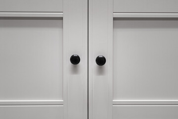 Minimal white closet or wardrobe with black door's handle. Interior  object photo, Close-up and selective focus at the knob handle.