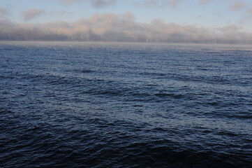 Vapour of haze over Vättern lake in Gränna in Sweden on a sunny winter day with blue sky, clear air and water