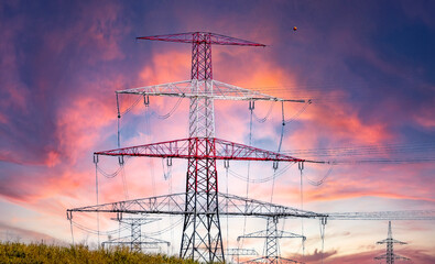 High voltage electricity pylons and transmission power lines on the blue sky background.