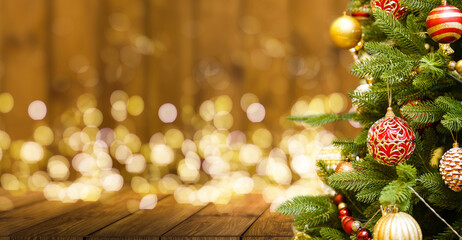 Fir Tree decorated with christmas balls on rustic wood and sparkles light backgorund
