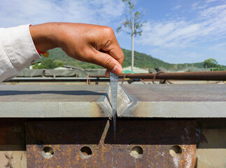 Using a taper gauge to measure the gap for joint preparation before welding add joint of steel...