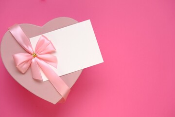 Valentine's day.Pink heart box with bow ,with white card On a light pale pink background. Gift heart.Blank postcard.Love and passion concept.Valentine's Day gift.copy space.Mother's day