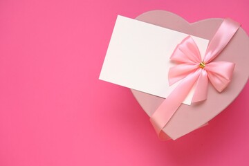 Valentine's day holiday.Pink heart box with bow ,with white card On a  pink background. Gift heart.Blank postcard.Love and passion concept.Valentine's Day gift.copy space.Mother's day