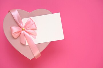 Valentine's day holiday.Pink heart box with bow ,with white card On a  pale pink background. Gift heart.Blank postcard.Love and passion concept.Valentine's Day gift.copy space.Mother's day