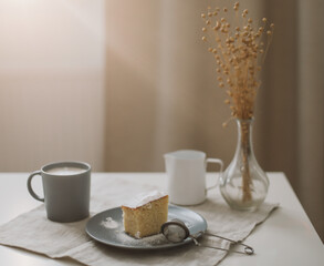 Fresh cake, pitcher and cup of coffee. Piece of fresh homemade cake with cup of cappuccino on a table. Morning breakfast