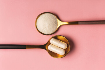 Collagen powder and pills on pink background. Extra protein intake. Natural beauty and health supplement for skin, bones, joints and gut. Plant or fish based. Flatlay, top view. Copy space.