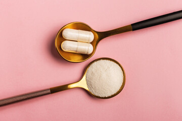 Collagen powder and pills on pink background. Extra protein intake. Natural beauty and health...