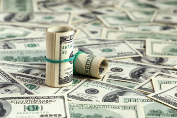 One hundred dollars banknotes, bundles and rolls background. US dollar bills texture or pattern. Money, finance, business concept. Close up, top view. Currency and savings. American