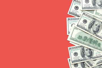 American 100 dollar bills on a light red colored background. Cash, currency. Copy space, top view, banner. Business, finance concept. Savings