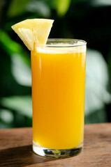 glass of fresh organic pineapple juice on table outdoors