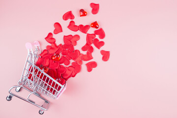 Valentine's Day online Shopping. Shopping cart with hearts on a pink background. 