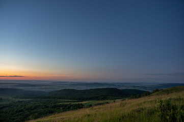 Naklejka na ściany i meble Panorama of a beautiful sunrise on the mountain in summer in Ukraine