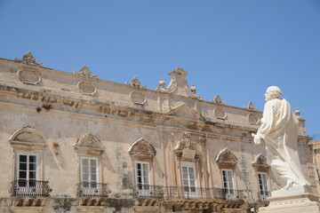 Fototapeta premium Syracuse is a city in Sicily. Here is the statue of St. Peter in front of the cathedral and the town hall in Duomo square in the peninsula of Ortigia which is the ancient center. 