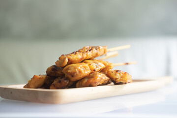 Sticks of grilled skewered turmeric chicken.