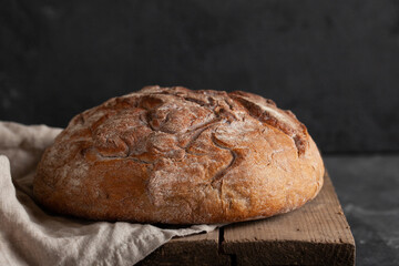 Fresh crusty homemade bread on wooden table.