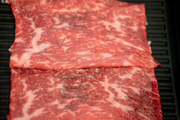 Fresh beef raw sliced with marbled texture served for Sukiyaki and Shabu or Yakiniku