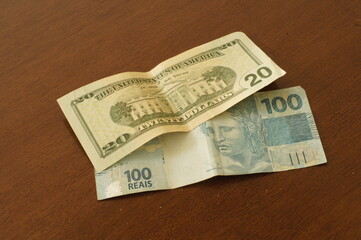 20 dollar bill that is worth a 100 Brazilian reais bill on a table in December 2020.