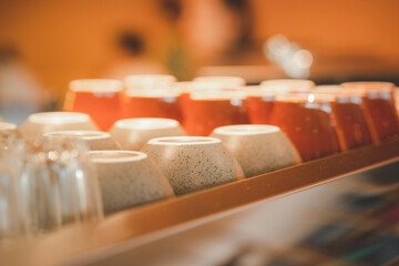Ceramic coffee cups on espresso machine shelf