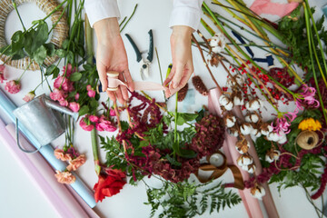 Fototapeta na wymiar A female florist holds threads for a bouquet. Hands close-up.
