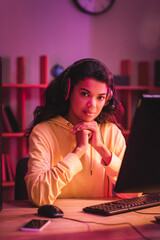 African american gamer in headset looking at camera near devices on blurred foreground © LIGHTFIELD STUDIOS