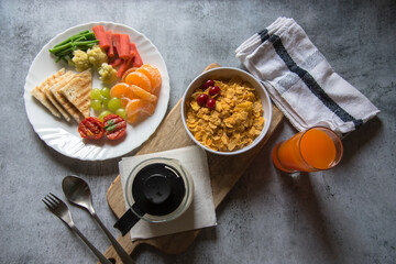 Top view of healthy breakfast items oranges, cornflakes with milk, juice, saute vegetables and fruits. 