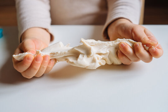 Close view of child's hands playing with homemade playdough. Children's creative game for early development and fine motor skills.
