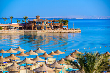 Relaxing at paradise beach - Chaise lounge and parasols - travel destination Hurghada, Egypt