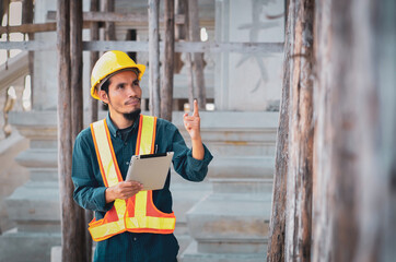 male engineer inspects the construction site with a tablet in his hand.