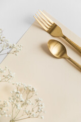 golden spoon and fork on a blank background. notes in the cafe