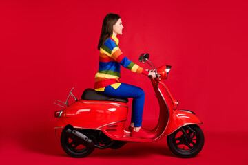 Fototapeta na wymiar Profile side view of attractive cheery girl driving bike going on tour free time isolated over bright red color background