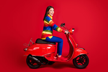 Fototapeta na wymiar Profile side view of pretty cheerful girl driving moped fast speed having fun isolated over bright red color background