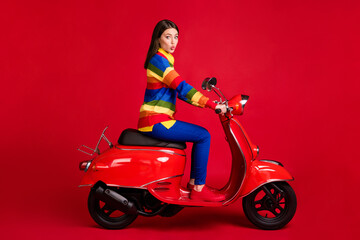 Obraz na płótnie Canvas Profile side view of pretty funky flirty girl driving moped having fun pout lips isolated over bright red color background
