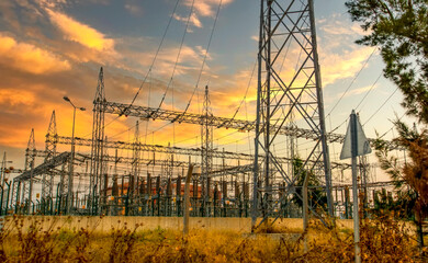High voltage electricity pylons and transmission power lines on the blue sky background.