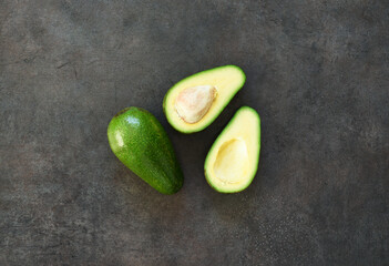 Avocado cut. Fresh avocado on a black stone background.