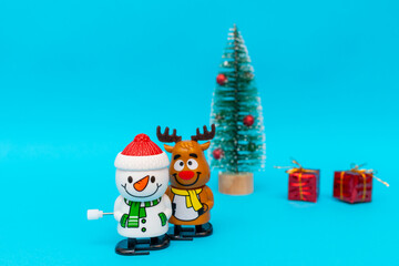 Front view Toys Snowman, deer, gift boxes on blue background with copy space
