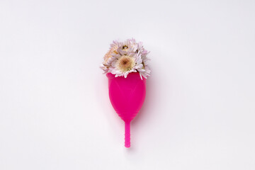 Menstrual cup with flowers on white background