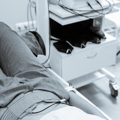 Young woman receiving hi top therapy in modern clinic. black and white image with blue tint to emphasize the concept of high technology