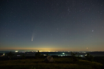 Comet in the night sky in the mountains