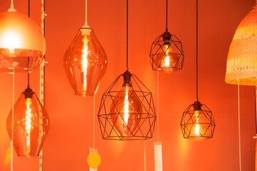 Many pendant lamps in different geometric shapes with a vintage glowing spiral of warm light.