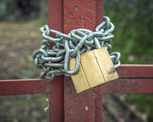Steel chain and a lock or padlock on a metal gate or door.