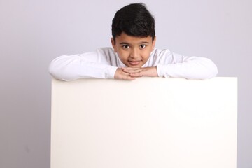 Young Indian schoolboy showing blank copy space.