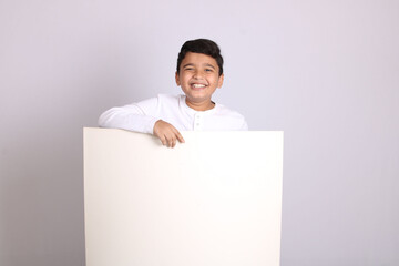 Young Indian schoolboy showing blank copy space.