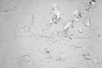 old plastered grey concrete wall surface with fragmentary paper stickers for abstract background or wallpaper