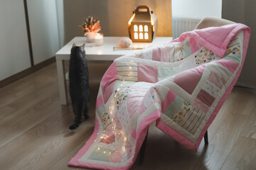 Cozy chair with blanket, knitting needles and funny cat. Cozy evening, leisure or hobby time....