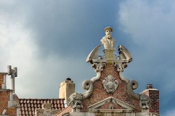 Fototapeta na wymiar old pediment with statue on a house of the Graslei in the historic city center of Ghent