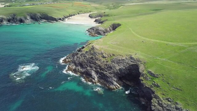 Lush Green Meadow At Kelsey Head With Poly Joke And Crantock Beach In Summer By Calm Blue Sea In Newquay, Cornwall, England. - aerial