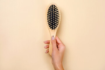 Wooden comb on beige background.